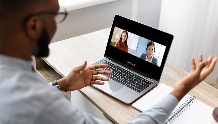 Man sitting at desk with laptop on a video call